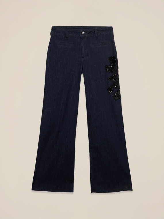 Blue rinse flare jeans with decorative patch