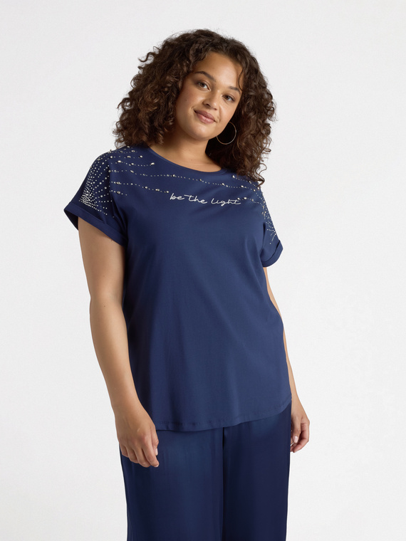 Camiseta con pedrería y escritura.