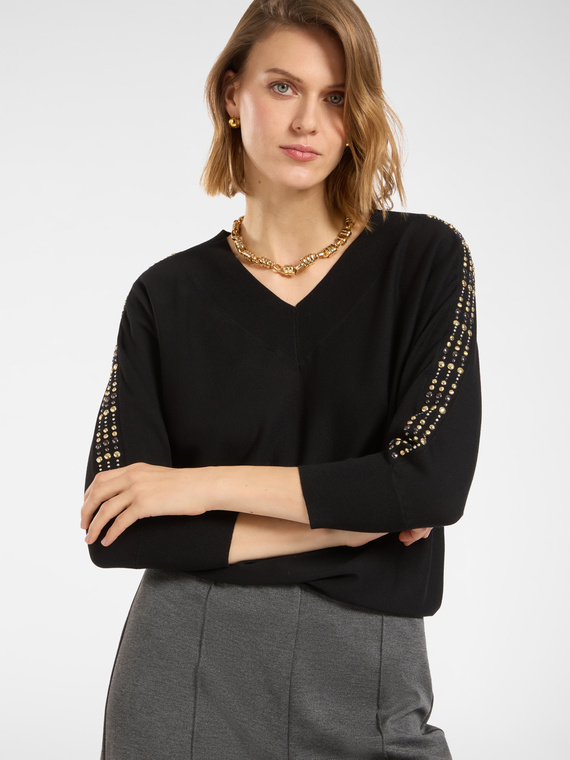 Pull avec des clous sur les manches