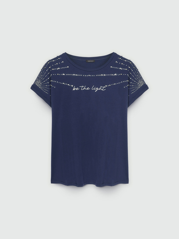 Camiseta con pedrería y escritura.
